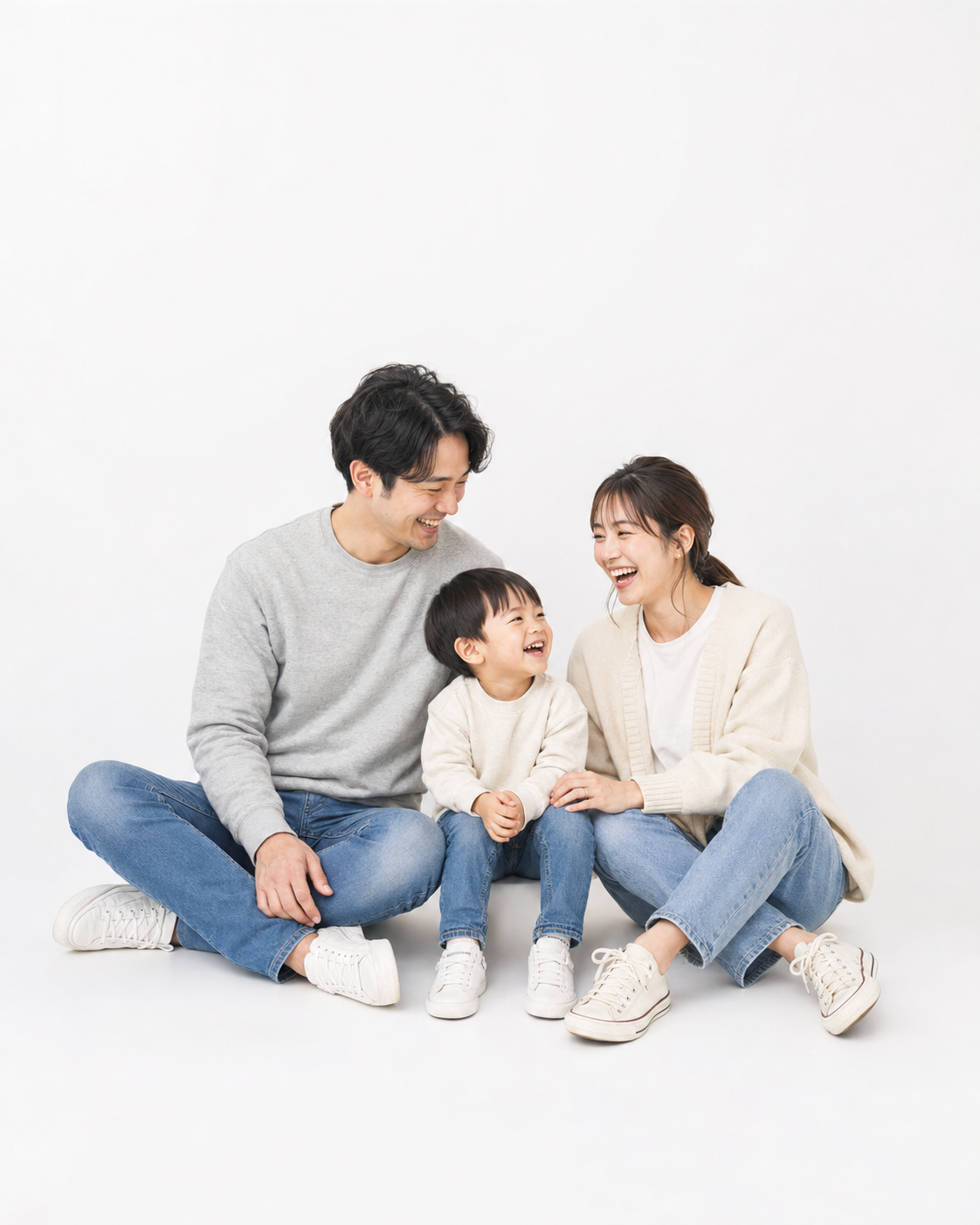 白背景の床に座る親子3人の家族写真